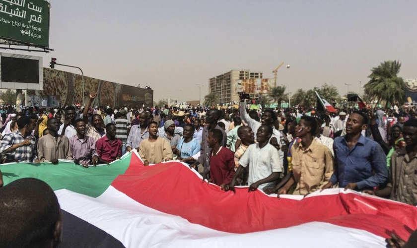 Sudaneses celebram a deposição do então presidente Omar al-Bashir em 2019, após 30 anos no poder. (Foto: Associated Press)