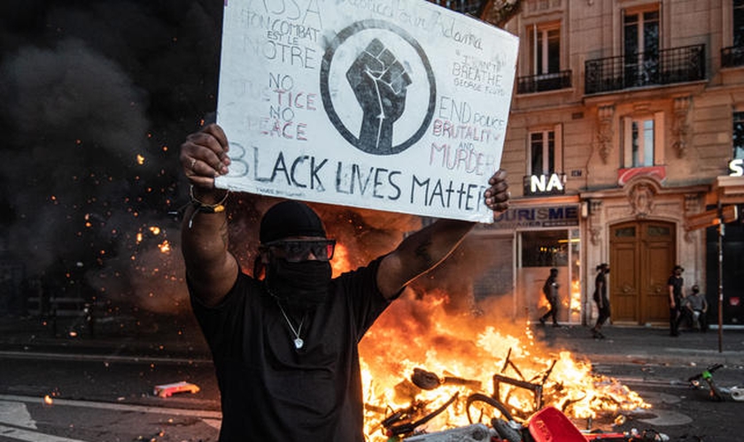 Militante do Black Lives Matter segura placa com símbolo do grupo durante manifestação violenta na França. (Foto: JULIEN BENJAMIN GUILLAUME MATTIA/ANADOLU AGENCY/GETTY)