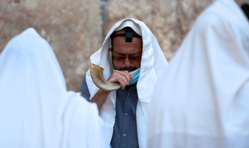 Um judeu ultraortodoxo toca um shofar, um instrumento musical feito de chifre de animal, enquanto ora antes do ano novo judaico no Muro das Lamentações. (Foto: AP Photo / Sebastian Scheiner)