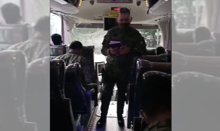O oficial MG Maliwat, da Polícia Nacional das Filipinas, prega aos amigos dentro do ônibus. (Foto: Reprodução / GOD TV)
