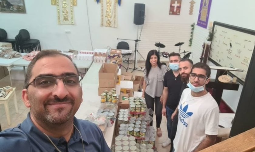 O pastor Saleem Shalash e voluntários da igreja se preparando para a distribuição de alimentos (Foto: Home of Jesus the King Church)