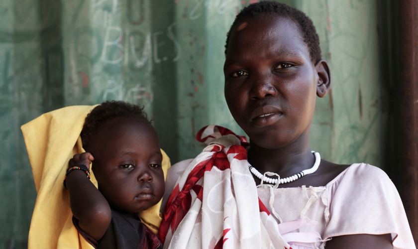 Nyamuot Joak segura sua filha de um ano, que sofre de desnutrição e está sendo tratada em uma clínica cristã no Sudão do Sul. (Foto: Andreea Campeanu/DEC)