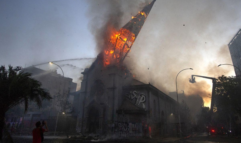 Igreja em chamas após ataque de manifestantes encapuzados em Santiago, no Chile. (Foto: AFP/Martin Bernetti)