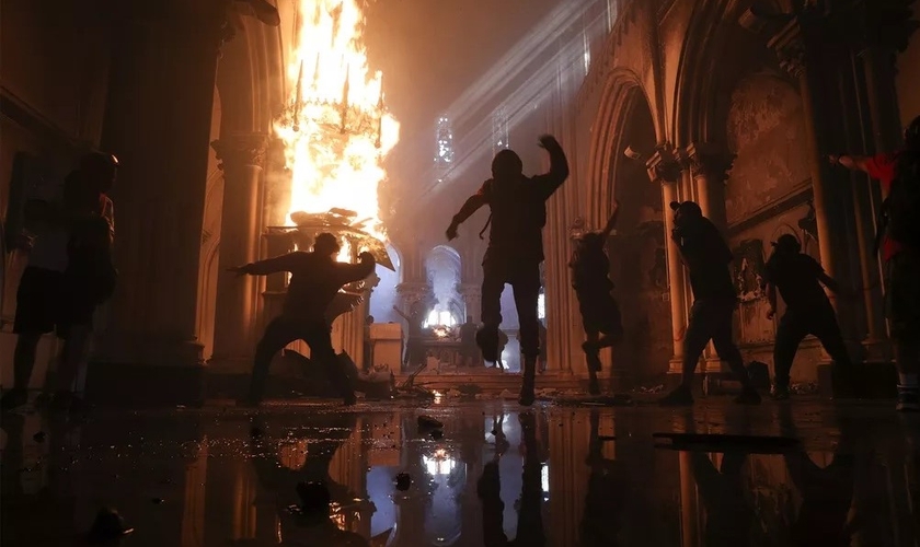 Vândalos destroem interior da Igreja de San Francisco de Borja, em Santiago, após início de confrontos em manifestação na capital do Chile. (Foto: Esteban Felt/AP)