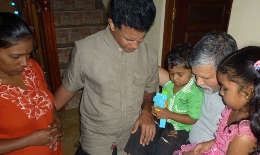 Pastor ora com cristãos no Sri Lanka. (Foto: Reprodução / Barnabas Fund)