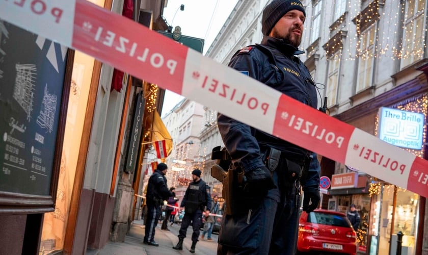 Policial austríaco permanece próximo a cordão de isolamento, em uma das cenas do ataque terrorista em Viena. (Foto: AFP)