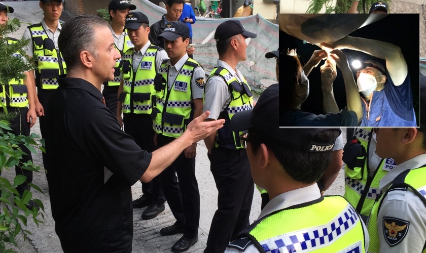 O Pr. Eric Foley conversa com policiais sul-coreanos; em destaque balões sento soltos. (Foto: Voice of the Martyrs Korea)