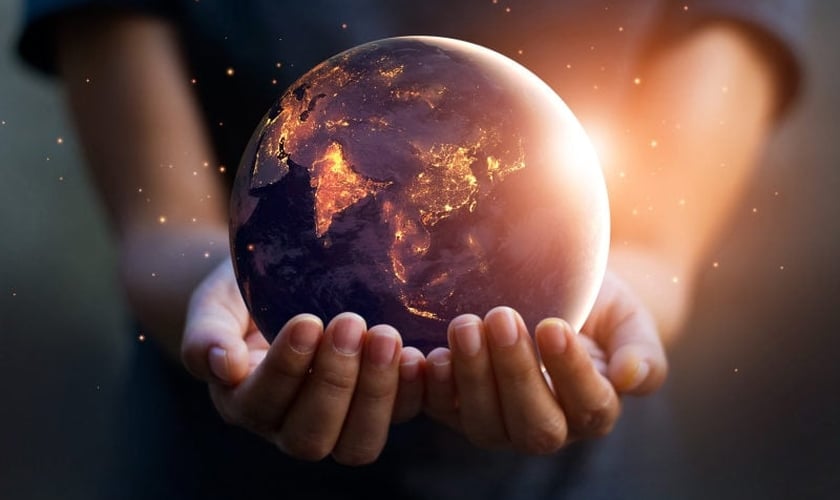Imagem ilustrativa de mãos humanas e o planeta Terra. (Foto: Shutterstock/Pop Tika)