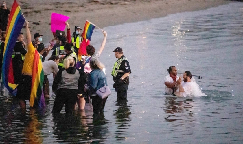 Multidão hostiliza o pregador de rua David Lynn durante batismo na English Bay, em Vancouver, em 31 de agosto de 2020. (Foto: The Canadian Press/Darryl Dyck)