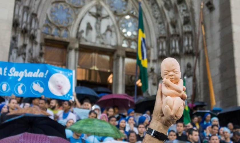 Manifestante pró-vida segura boneco de feto em protesto contra aborto. (Foto: Marcha Pela Vida Brasil)
