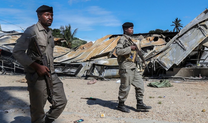 Soldados do exército moçambicano passam por um prédio destruído por insurgentes ligados ao Estado Islâmico em Palma, Moçambique. (Foto: João Relvas/EPA/Shutterstock)