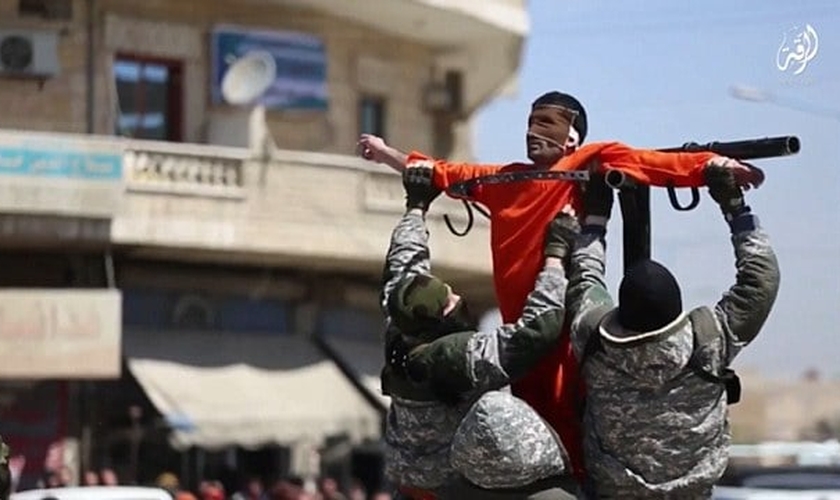 Com o rosto vendado, homem é crucificado por dois carrascos do Estado Islâmico. (Foto: Reprodução/Daily Mail)