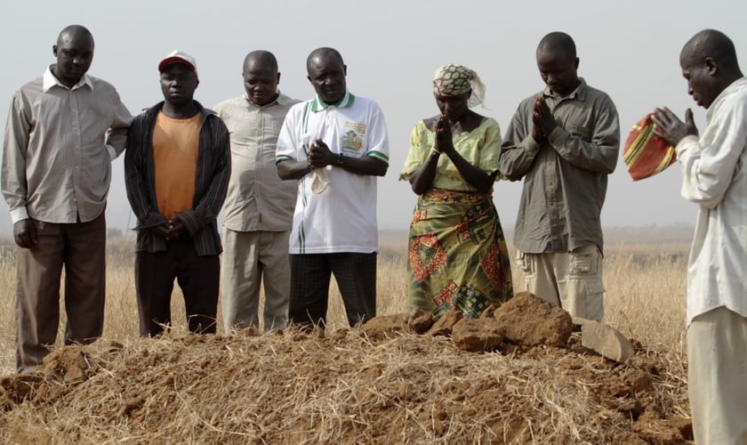 Pessoas se reúnem ao redor de uma sepultura, onde três parentes assassinados foram enterrados juntos, em Jos, no estado de Plateau, na Nigéria, em 28 de dezembro de 2011.  (Foto: Afolabi Sotunde/Reuters).