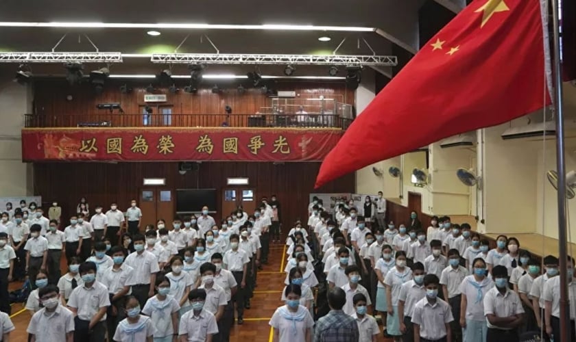 Alunos participam de uma cerimônia de hasteamento da bandeira, no Dia da Educação para a Segurança Nacional, numa escola em Hong Kong, 15 de abril de 2021. (Foto: AP Photo/Kin Cheung)