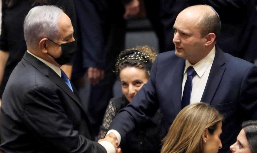 Benjamin Netanyahu e Naftali Bennett apertam as mãos após votação no Knesset. (Foto: Reuters/Ronen Zvulun)