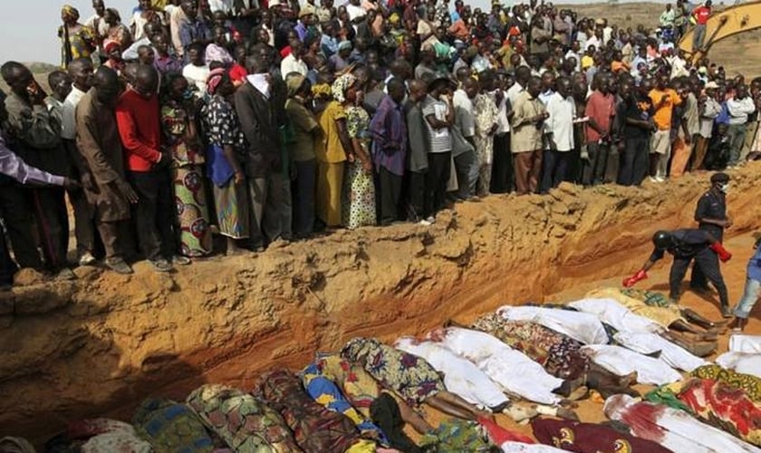 Aldeões observando corpos de vítimas de violência étnica entre fazendeiros de Berom e pastores Fulani, na vila de Dogo Nahawa, na Nigéria, em 2010. (Foto: Reuters).