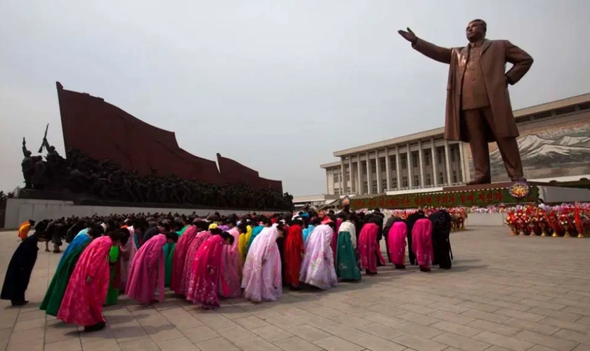 Norte-coreanos prestam reverência a uma estátua de Kim Il-Sung, que criou sua própria religião em Pyongyang. (Foto: David Gittenfelder/AP/Veja)