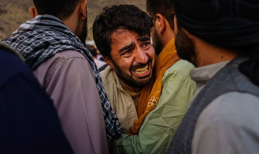 Homem chora durante enterro em massa no Afeganistão. (Foto: Marcus Yam/Los Angeles Times/Rex)