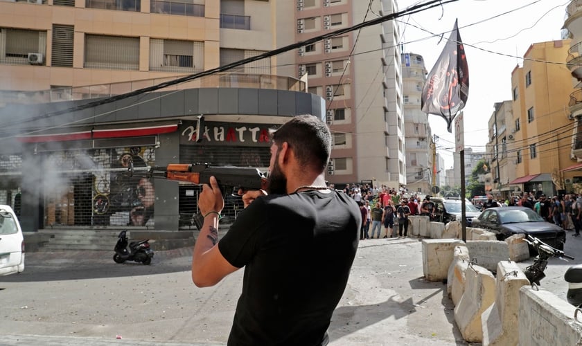 Um homem dispara sua arma no bairro de Tayuné durante os confrontos desta quinta-feira no Líbano. (Foto: Anwar Amro / AFP)