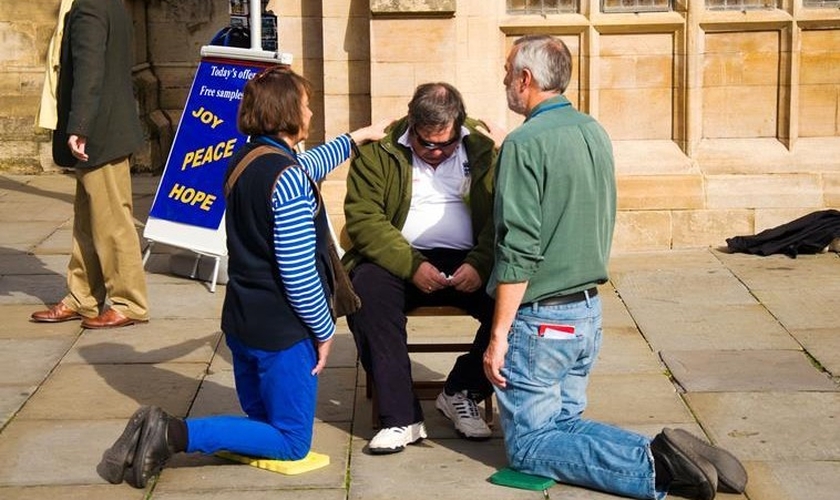 Cristãos oram na rua por uma pessoa. (Foto: Reprodução / Premier)