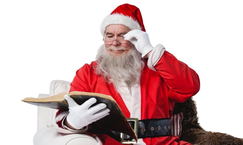 Papai Noel consultando a Bíblia. (Foto: Canva)