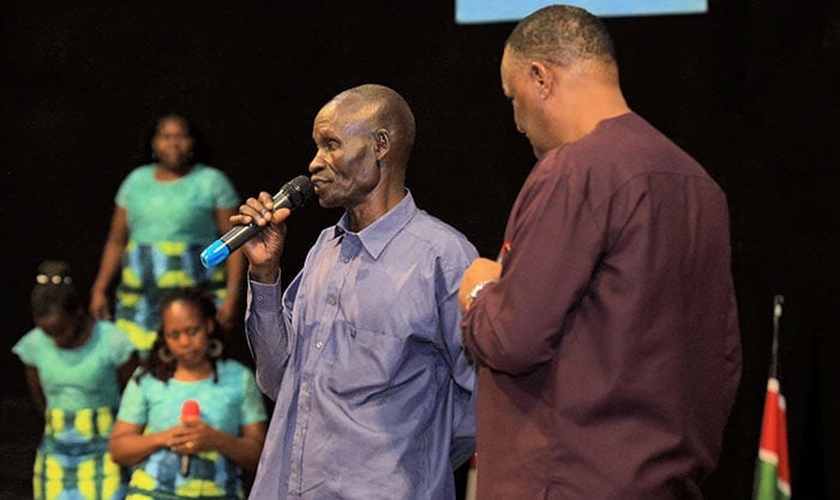 Homem conta seu testemunho após receber oração do Pr. Gerald Mwebe, no culto de Páscoa. (Reprodução / UGCN)