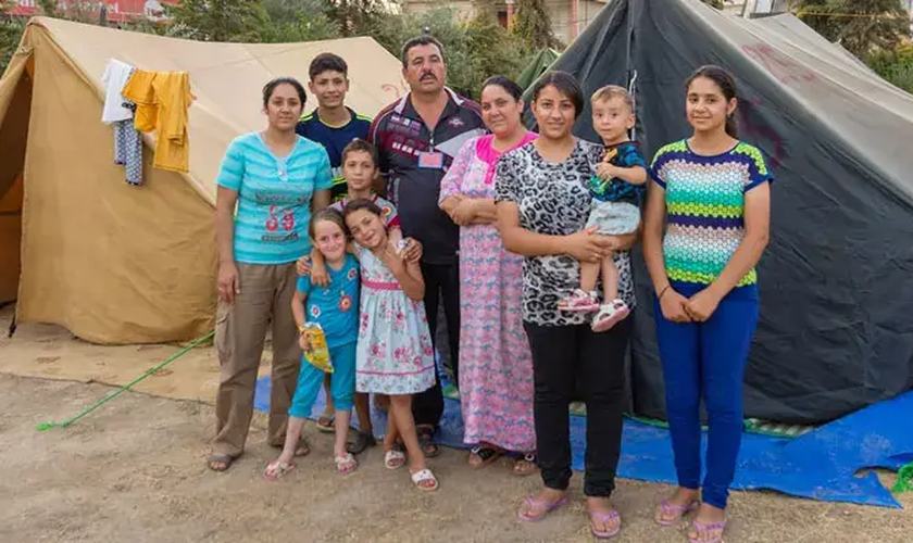 Família em frente a sua tenda após ter que fugir do Iraque por conta dos ataques do Estado Islâmico. (Foto: Portas Abertas)