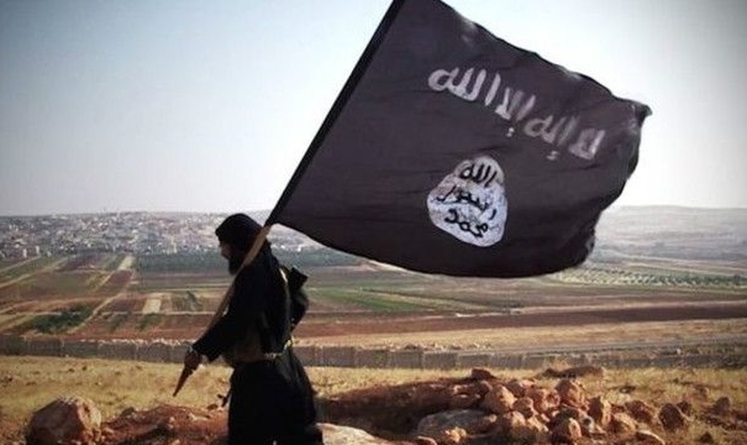 Militante islâmico com a bandeira do grupo terrorista. (Foto: Wikipedia)