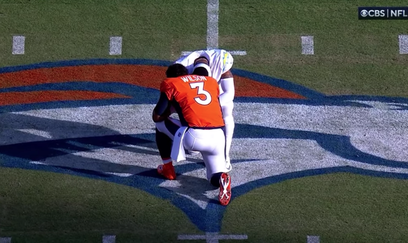 Atletas se ajoelham em campo para orar por Damar Hamlin. (Foto: Reprodução/CBS)