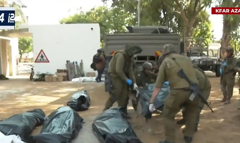 Corpos dos moradores do kibutz Kfar Aza são retirados por policiais israelenses. (Captura de tela/YouTube i24News)