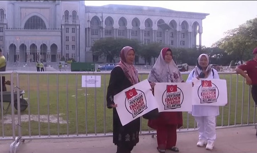 Manifestantes com cartazes em defesa da sharia. (Captura de tela/YouTube/CNA)