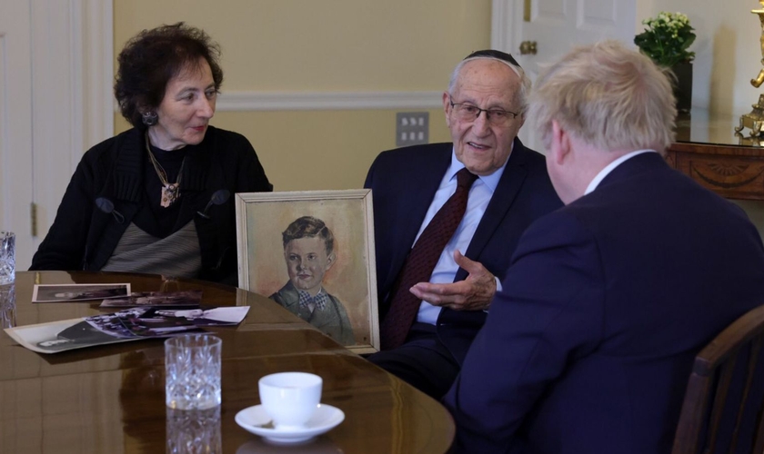 Manfred Goldberg e sua esposa em um encontro com o ex-primeiro-ministro do Reino Unido, mostrando uma foto de seu irmão Herman. (Foto: Reprodução/Flickr/Number 10)