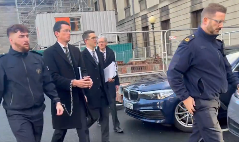 O professor Enoch Burke sendo levado pela polícia com as mãos acorrentadas. (Captura de tela/X/Enoch Burke)