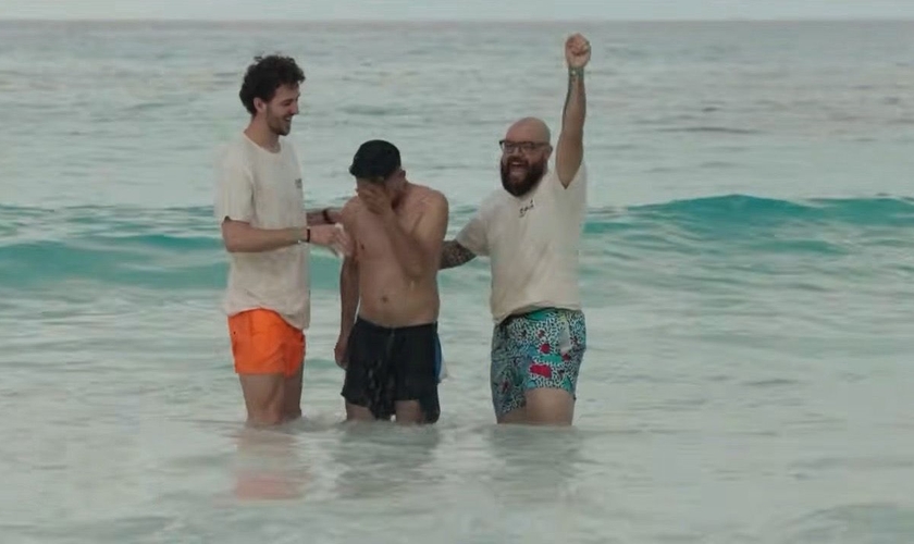 Jovem é batizado durante ação evangelística em praia de Cancún. (Captura de tela/YouTube/CBN News)