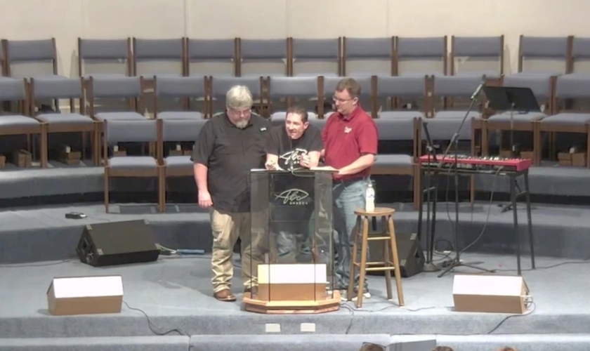 Pastor Matt Olson é amparado durante a maratona de pregação da Bíblia. (Captura de tela/Primeira Igreja Batista de Sharon)