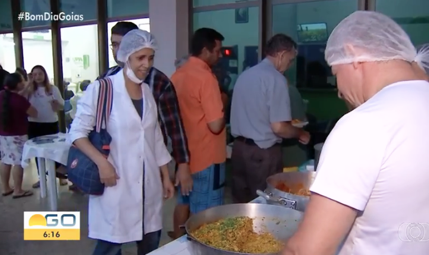 Voluntários da igreja distribuem comida para acompanhantes e funcionários de UPA. (Foto: Bom Dia Goiás/TV Anhanguera)