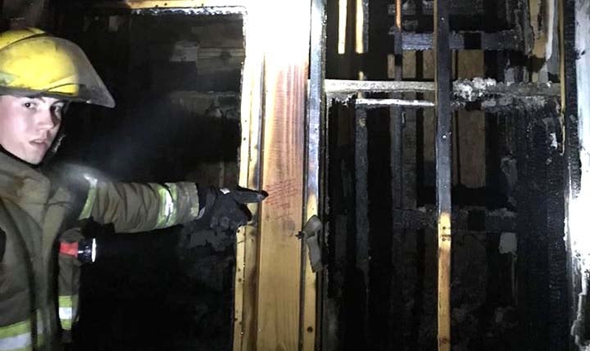 Bombeiro aponta para um dos versículos que não foi atingido pelas chamas. (Foto: Livingston Parish Fire Protection District #2)