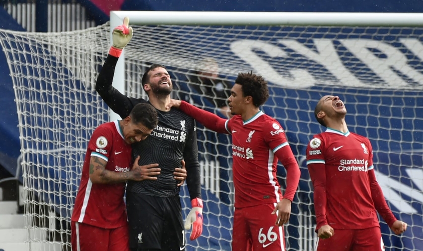 Alisson Becker, goleiro do Liverpool, aponta para o céu após surpreendente vitória. (Foto: Rui Vieira/Reuters)