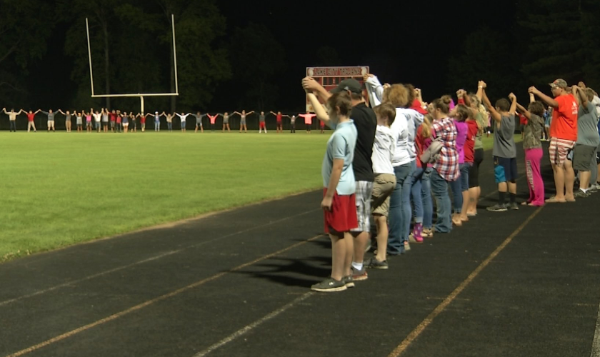 Estudantes reunidos em oração pela pequena Harper no campo de futebol da escola Lake City High School. (Foto: Twitter/Megan Viecelli)