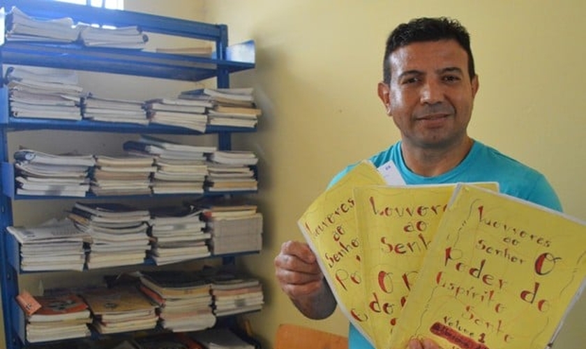 Detento com mostra as histórias que escreveu em sua coletânea. (Foto: Divulgação/Sejus)
