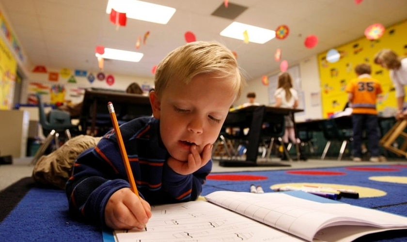 O pequeno Adam Kotzian escolher fazer o seu dever deitado no chão de sua sala de aula, na Eagleview Elementary School, no Estado do Colorado (EUA)