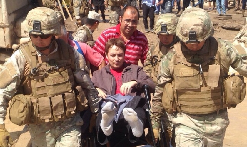 Pastor Rúben sendo carregado por militares.