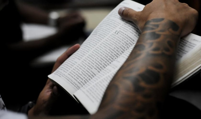 Jovem segurando a Bíblia durante culto em uma igreja evangélica, em São Paulo. (Foto: Christian Tragni/ Folhapress)