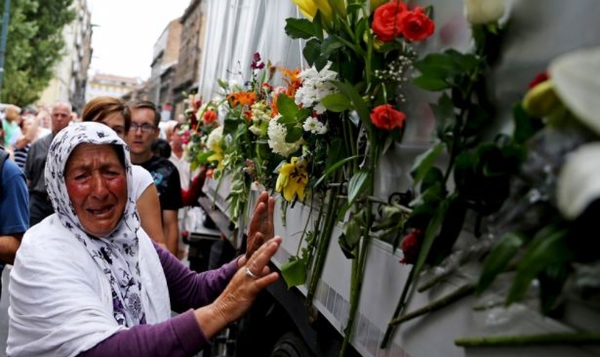 Uma mulher chora ao lado de um caminhão que transportava 136 caixões de recém-identificadas vítimas do massacre de Srebrenica, em 1.995 (Foto: Reuters)
