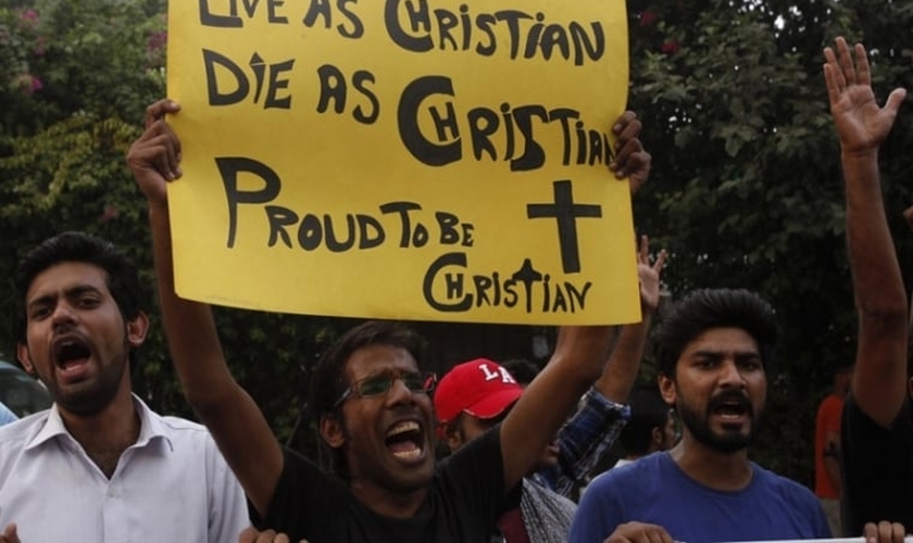 Manifestante paquistanês segura cartaz com as frases: "Viver como cristão! Morrer como cristão! Orgulho de ser cristão!". (Foto: Reuters)