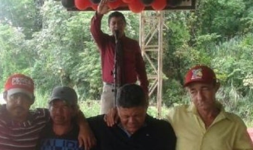 Pastor João Bispo ora pelos necessitados, enquanto os recebe em sua festa de aniversário. (Foto: Reprodução)