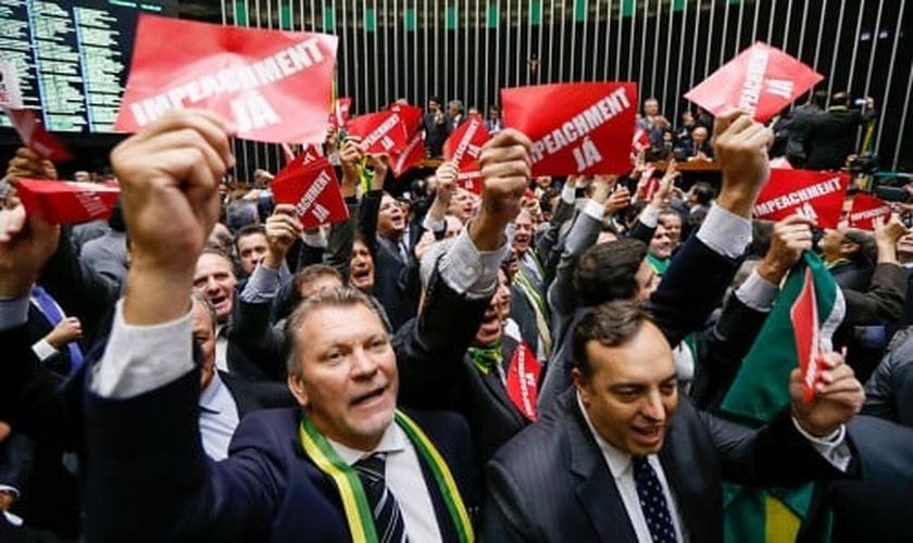 Deputados exibem cartões com a frase "impeachment já" no Plenário da Câmara. (Foto: Folha.com)
