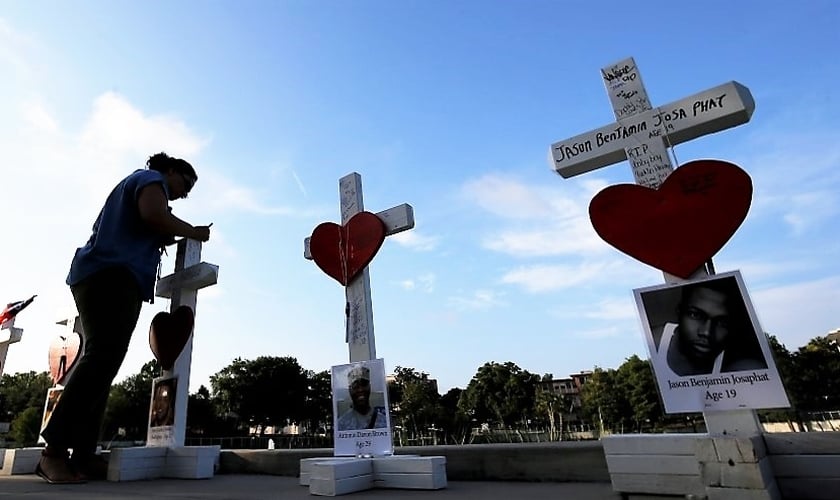 Mulher escreve uma mensagem em uma cruz em honra daqueles que foram mortos na boate gay 'Pulse', em Orlando. (Foto: Reuters)