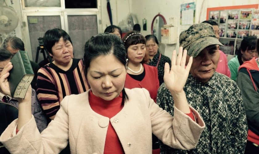 Cristãos em oração numa pequena igreja subterrânea que acontece numa loja em Pequim, na China. (Foto: Wayne Mcallister)