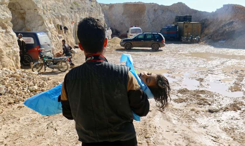 Homem carrega o corpo de uma criança morta após ataque químico em Khan Sheikhoun. (Foto: Ammar Abdullah/Reuters)